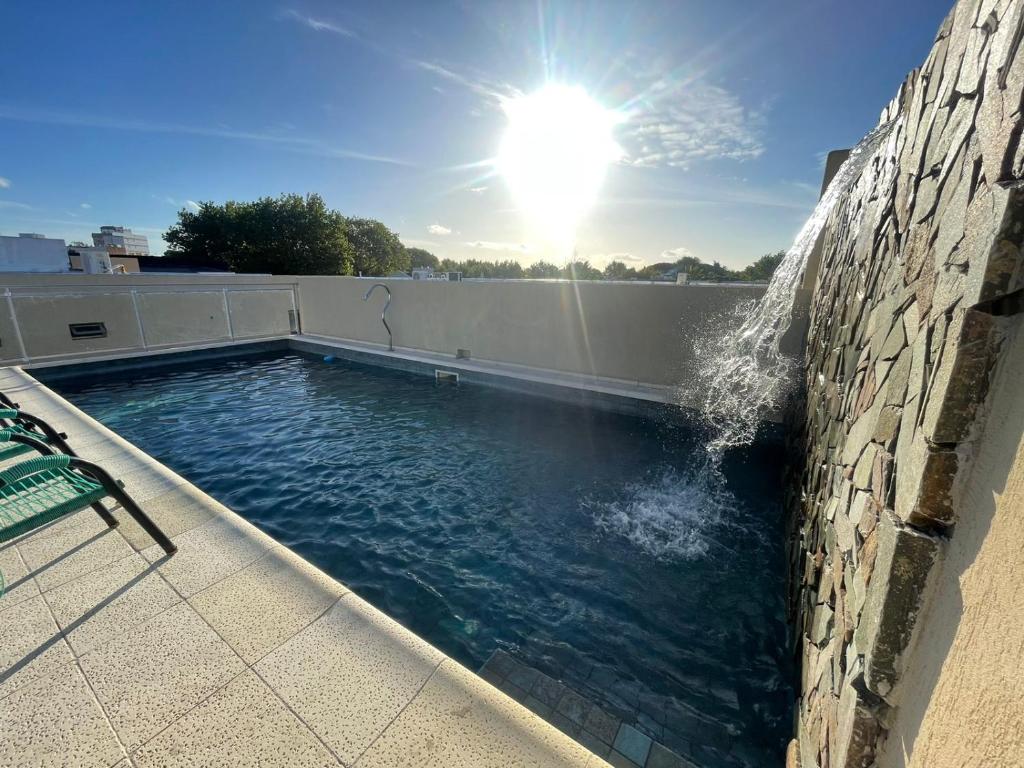 a swimming pool with water coming out of a wall at Gran Tuyu in San Clemente del Tuyú