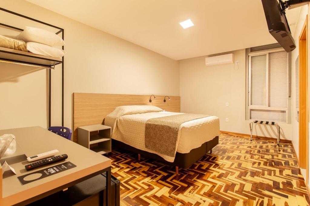 a hotel room with a bed and a desk at Hotel Dom Rafael Business in Santa Maria