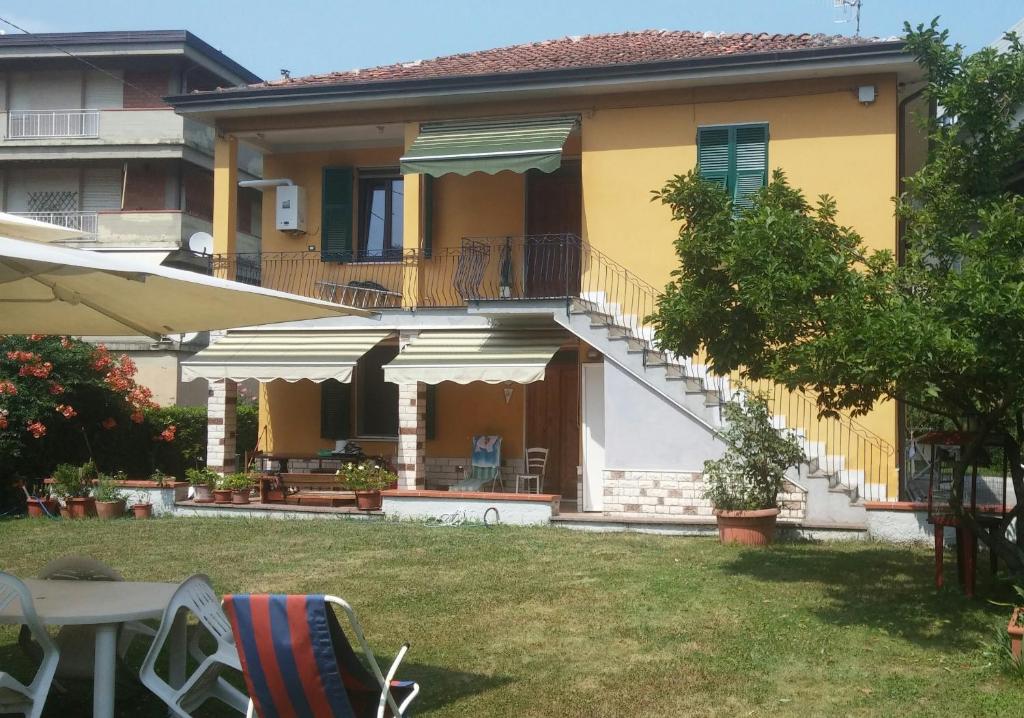 a yellow house with a balcony and a yard at Casa Il Sogno in Vezzano Ligure