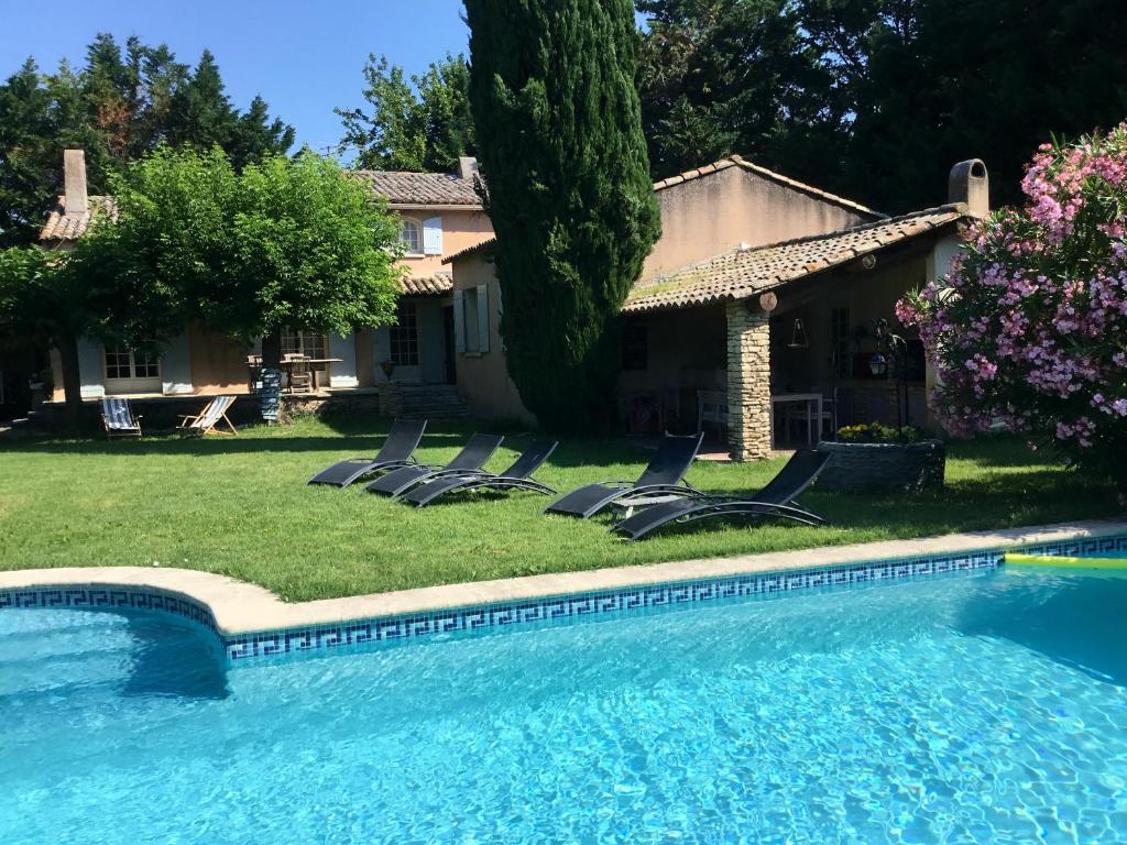 una piscina con tumbonas junto a una casa en Villa de 3 chambres avec piscine privee jardin clos et wifi a Althen des Paluds, en Althen-des-Paluds