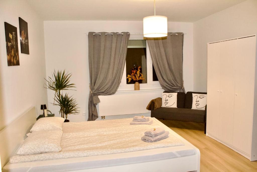 a white bedroom with a bed and a couch at Apartments zum Bühlhof (Julie) in Zurich