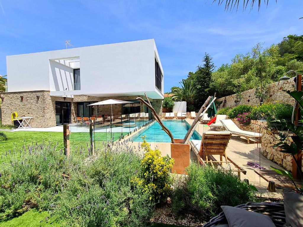 a villa with a swimming pool and a house at Mitjana's House in Cala Galdana