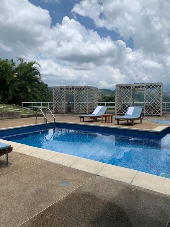 a swimming pool with two lounge chairs next to it at Mesod Jungle Boutique in Caracas