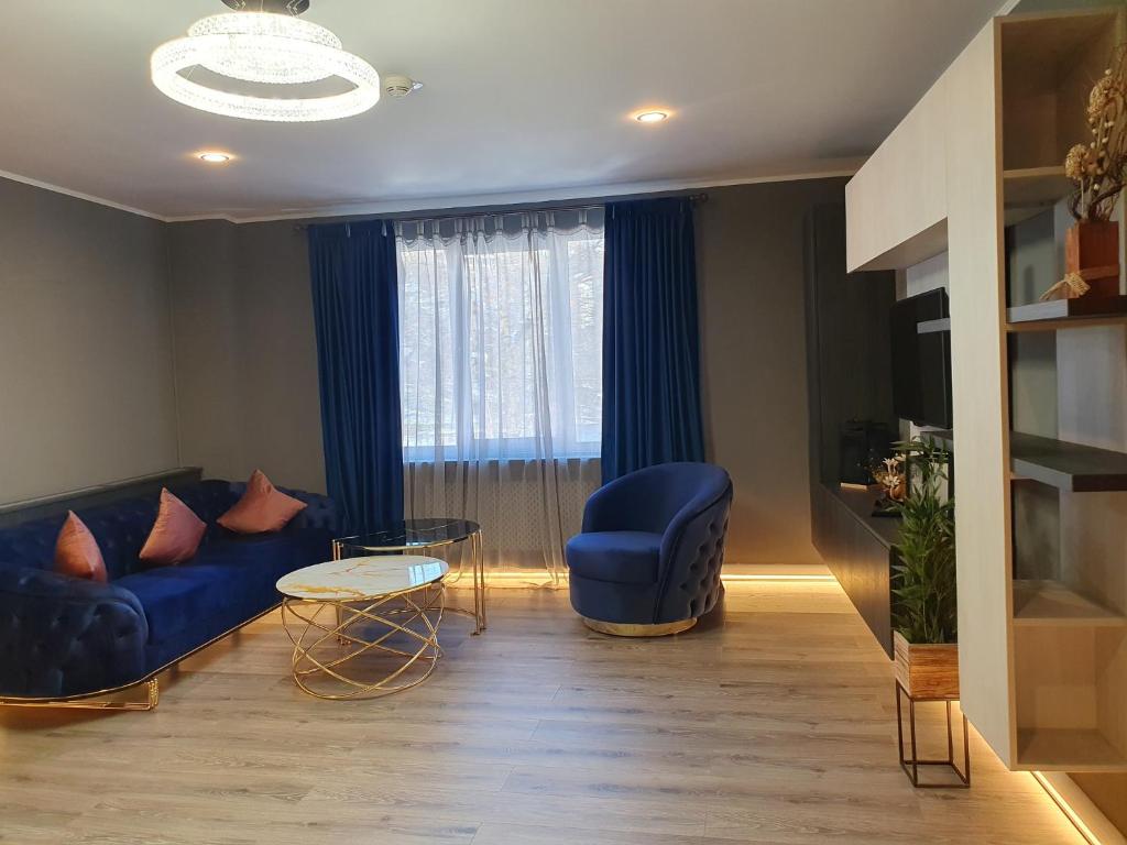 a living room with a blue couch and a window at Irish House in Sinaia