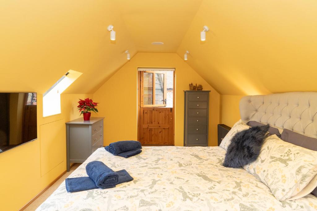 um quarto com uma cama grande e almofadas azuis em Mattie's Loft em Bletchingley