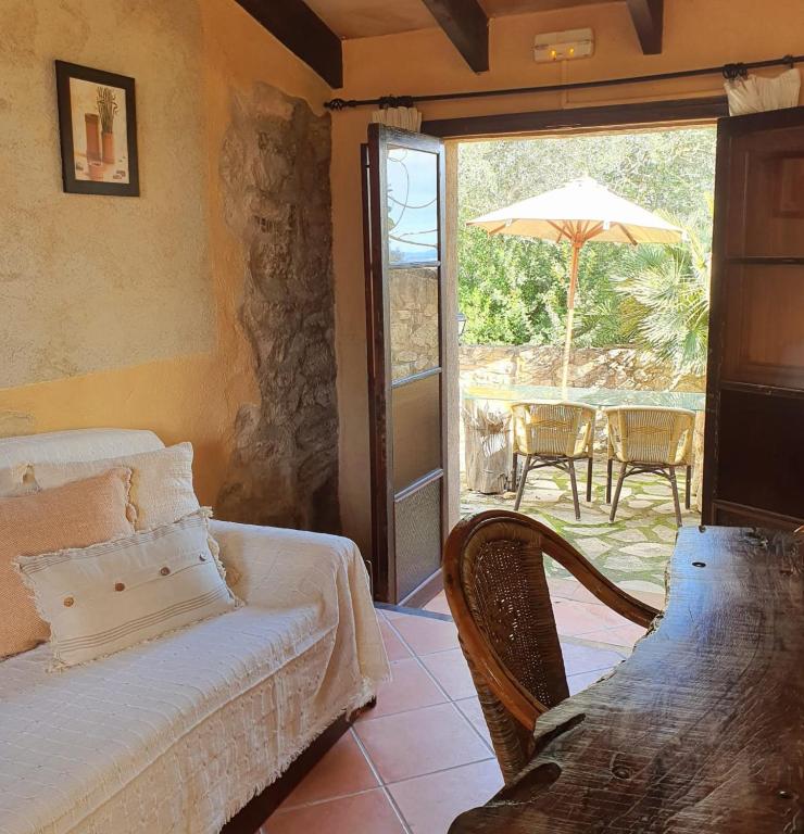 um quarto com uma cama e um pátio com um guarda-chuva em Agroturismo Son Torrat Apartment Es Forn em Petra