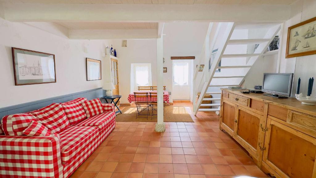 a living room with a couch and a television at Petite maison de village avec étage in La Couarde-sur-Mer