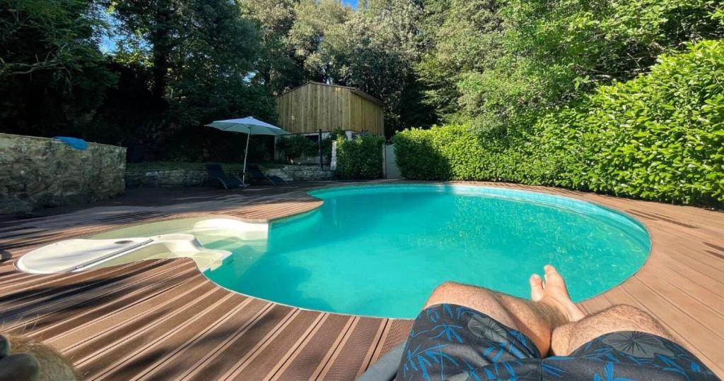 une personne dormant sur une terrasse à côté d'une piscine dans l'établissement La Boetie du Ponchet, à Veyrignac