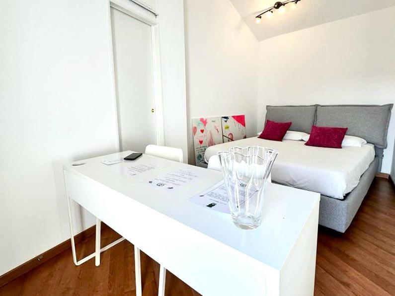 Camera bianca con letto e tavolo bianco di ComeCasa 2 bedrooms Larga apartment a Milano