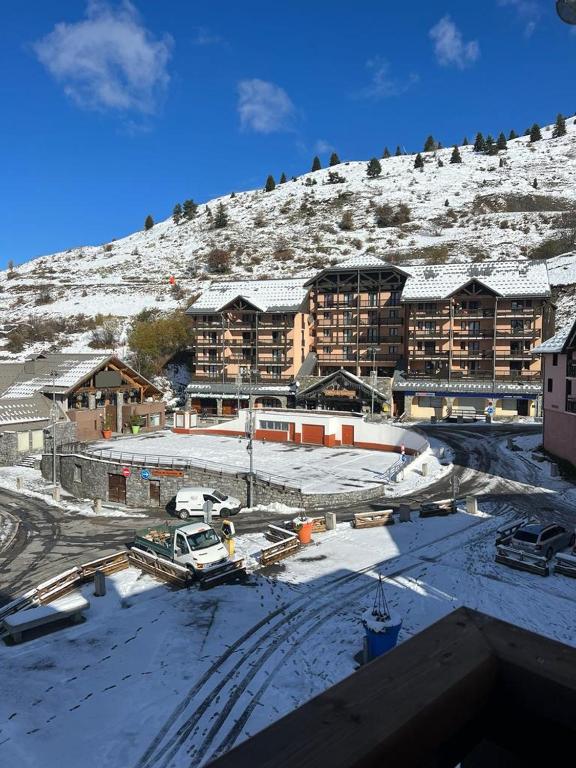 un grand bâtiment avec de la neige sur une montagne dans l'établissement Valmeinier 1800 studio Front de neige, à Le Désert