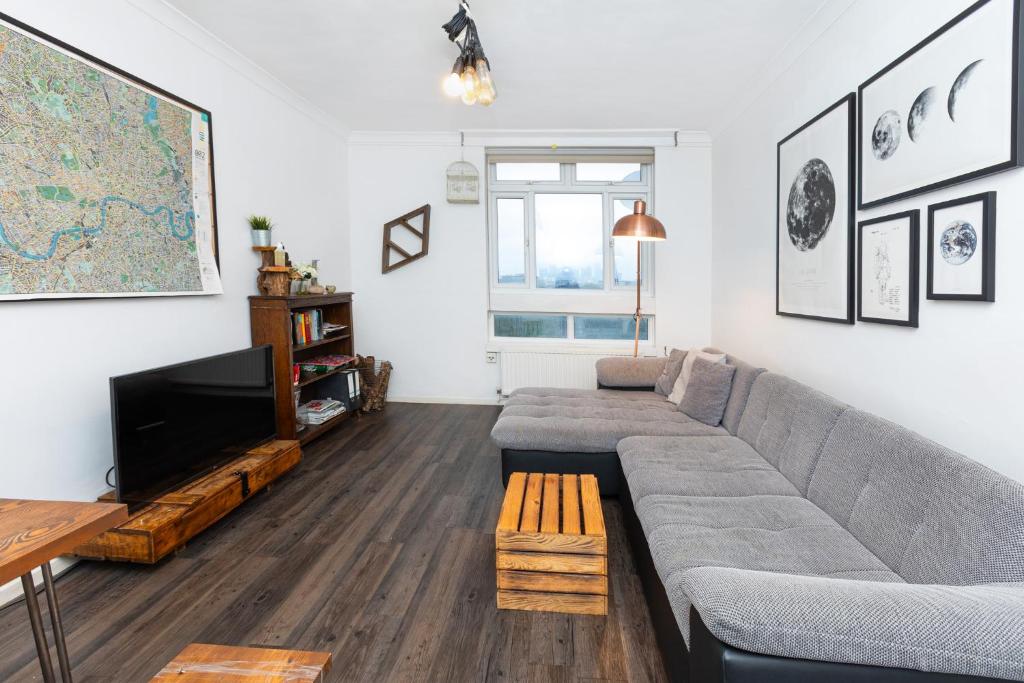 a living room with a couch and a tv at Gorgeous 2BDR Flat in Shoreditch in London