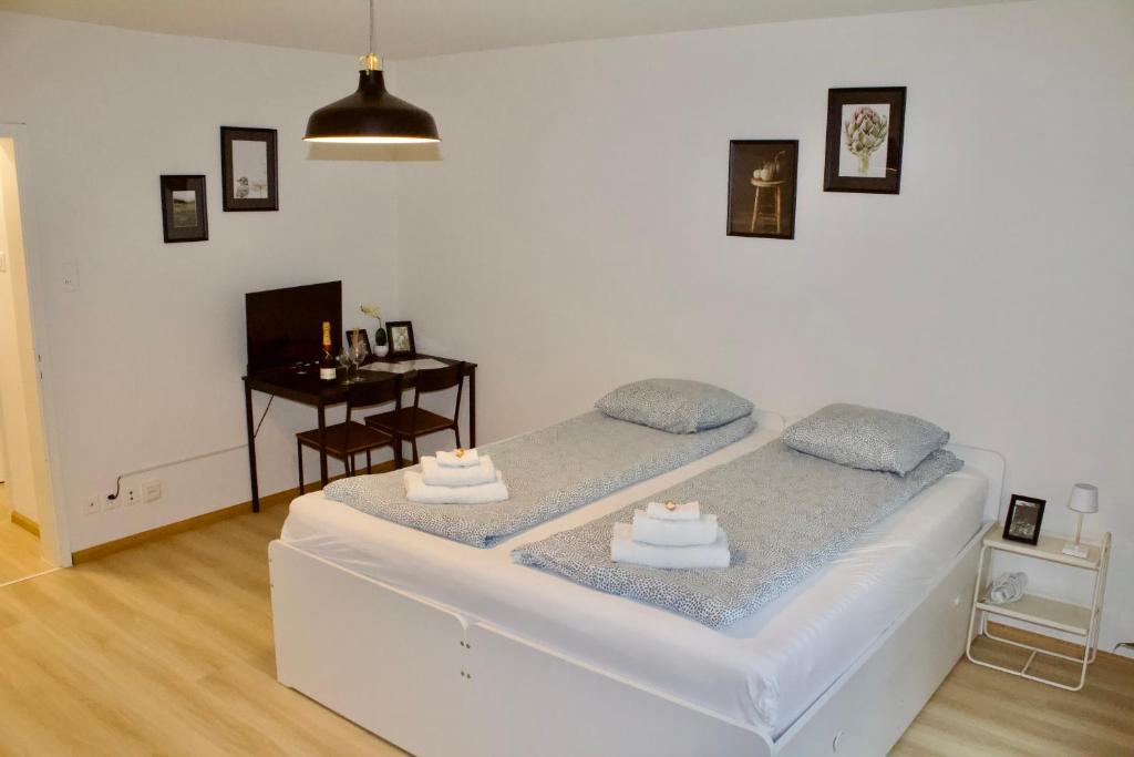 a white room with two beds and a table at Apartments zum Bühlhof (Alfred) in Zurich