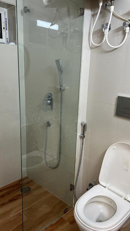 een badkamer met een douche en een toilet bij Rungta home sweet home in Calcutta