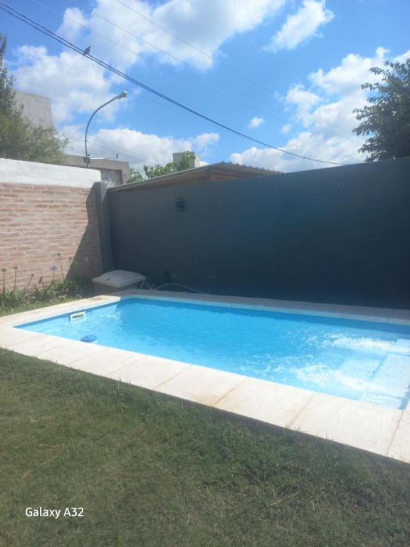 a swimming pool in a yard next to a building at Casa Deco con Pileta, Asador y Cochera in Cordoba