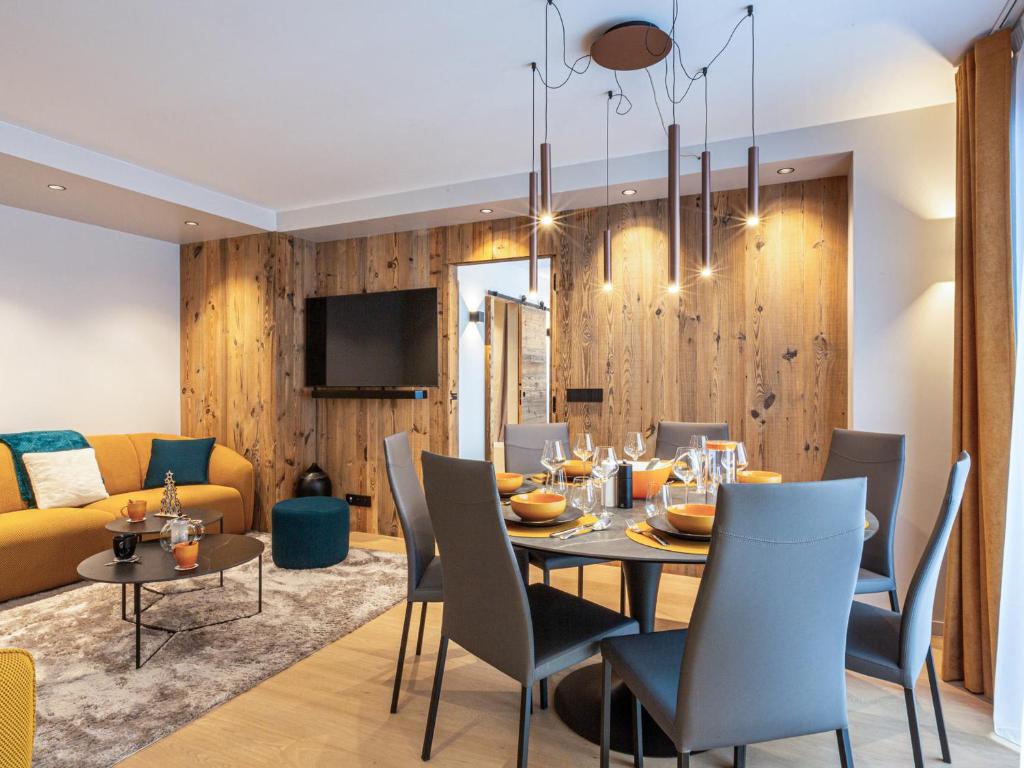 une salle à manger et un salon avec une table et des chaises dans l'établissement Appartement raffiné avec accès direct aux pistes, wifi et parking 2 places - FR-1-694-346, à Val dʼIsère