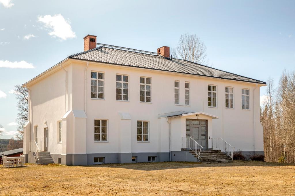 a large white house with a yard at Vakantievilla Rämmen Skola in Rämmen