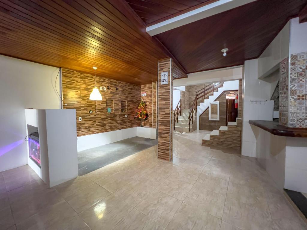 a lobby with stairs and a stone wall at pousada Vitoria in Morro de São Paulo