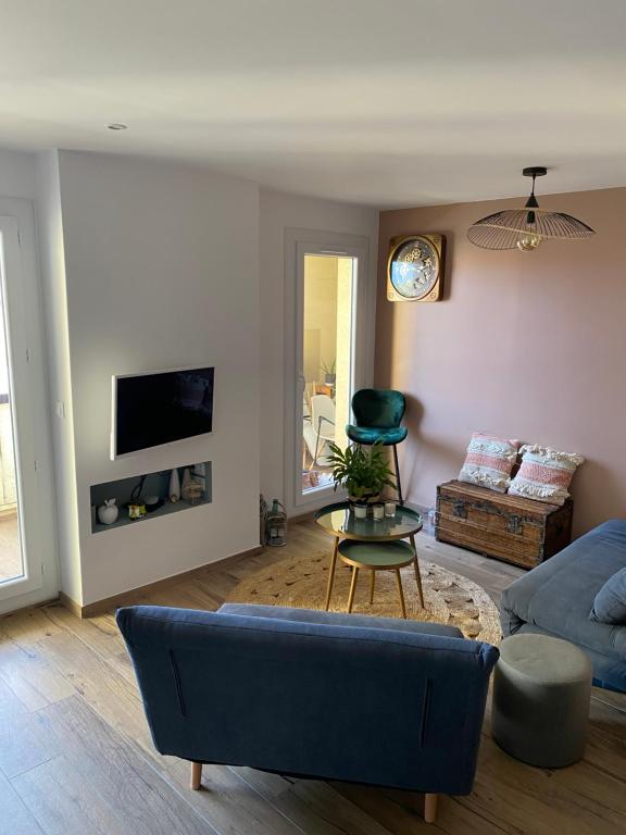 un salon avec un canapé bleu et une chaise dans l'établissement Cocon idéalement situé entre terre et mer, à Argelès-sur-Mer