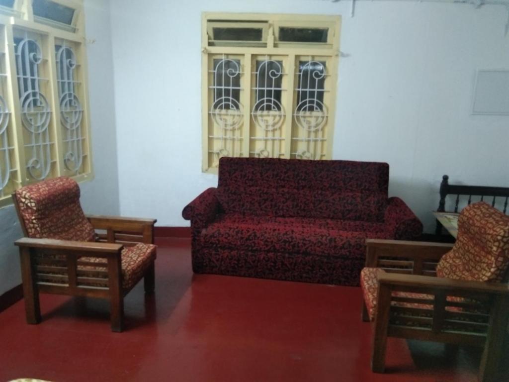 sala de estar con sofá y 2 sillas en C. L Inn, en Kochi