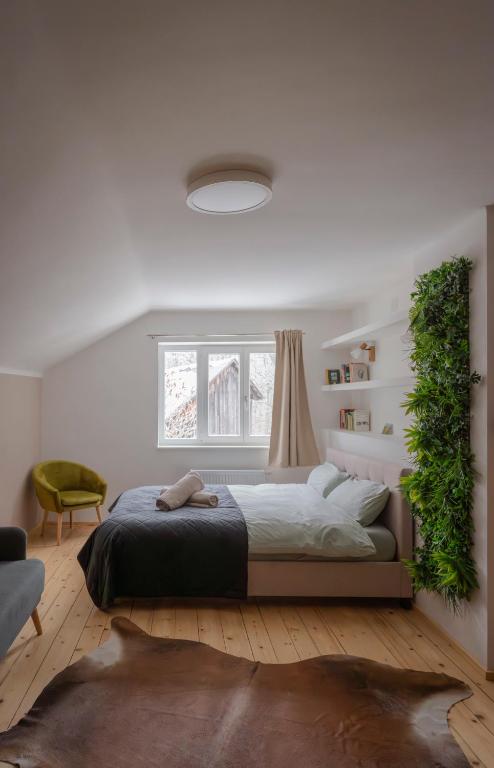 a bedroom with a bed with a green plant on the wall at ALBA MOUNTAIN CHALETS in Gusswerk