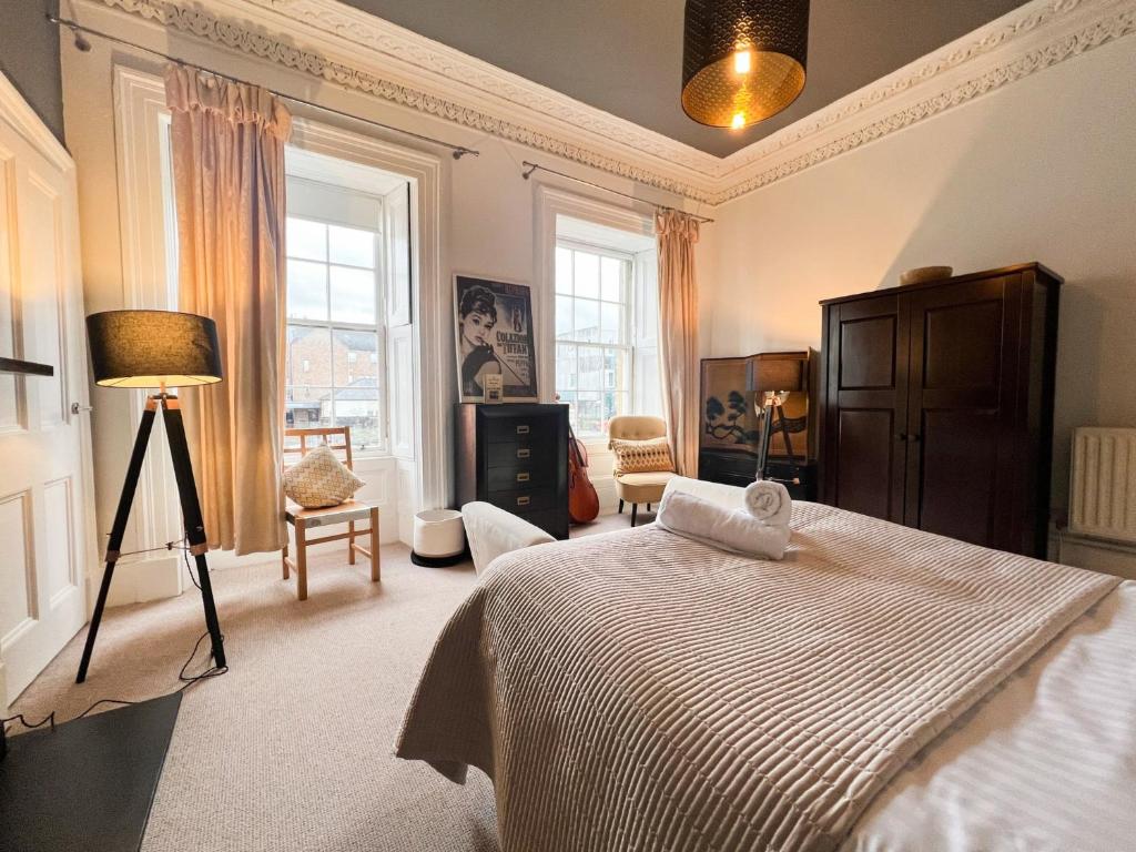 1 dormitorio con cama, lámpara y ventanas en Garnethill Charm 3 Bed Flat Central Glasgow en Glasgow