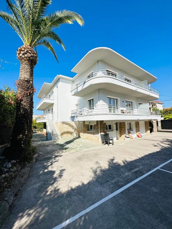 un bâtiment blanc avec un palmier devant dans l'établissement LOTI, à Antibes