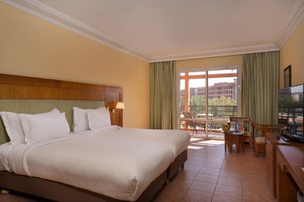 Postel nebo postele na pokoji v ubytování Grand Mogador Menara & Spa