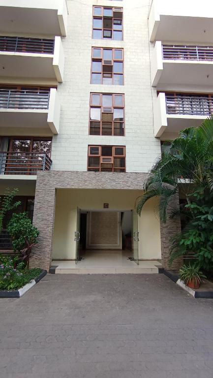 un grande edificio con un parcheggio di fronte di Baraka Suites, Nyali Gulf Links Apartment by Gash Homestays C-1 a Mombasa