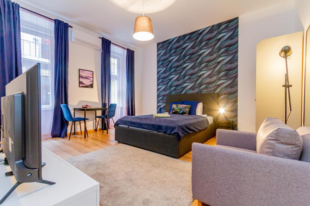 een slaapkamer met een bed en een tv en een bank bij I.K.Apartments in Boedapest