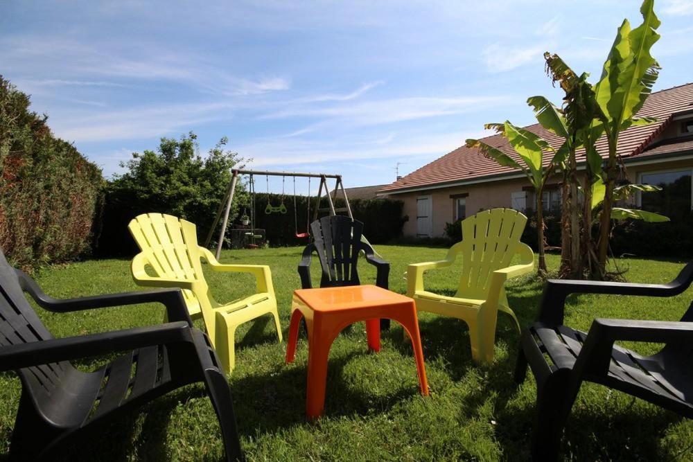 grupa krzeseł i huśtawka na podwórku w obiekcie Le champ Vert 
