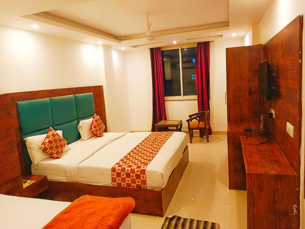 Hotel Tark Plaza Near IGI Airport Delhi في نيودلهي: غرفه فندقيه سرير وتلفزيون