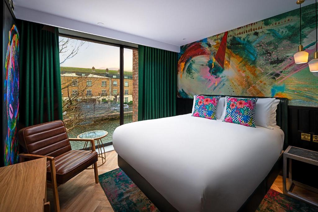 um quarto com uma cama branca e uma grande janela em NYX Hotel Dublin Portobello em Dublin