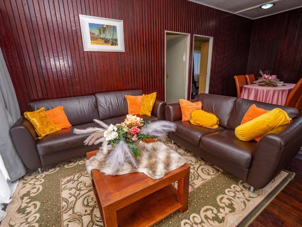 sala de estar con sofá de cuero marrón y almohadas amarillas en Stunning 3-Bed House in Paramaribo Marie's place, en Paramaribo