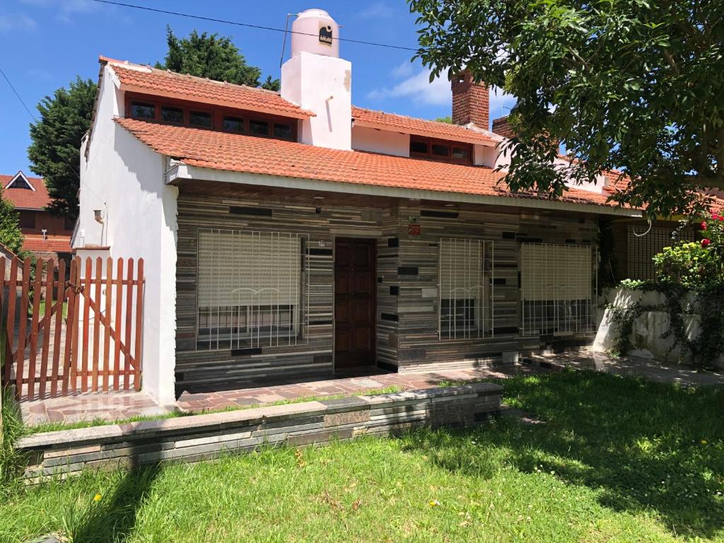une vieille maison avec une clôture et un portail dans l'établissement Casa Santa Clara del Mar, à Santa Clara del Mar