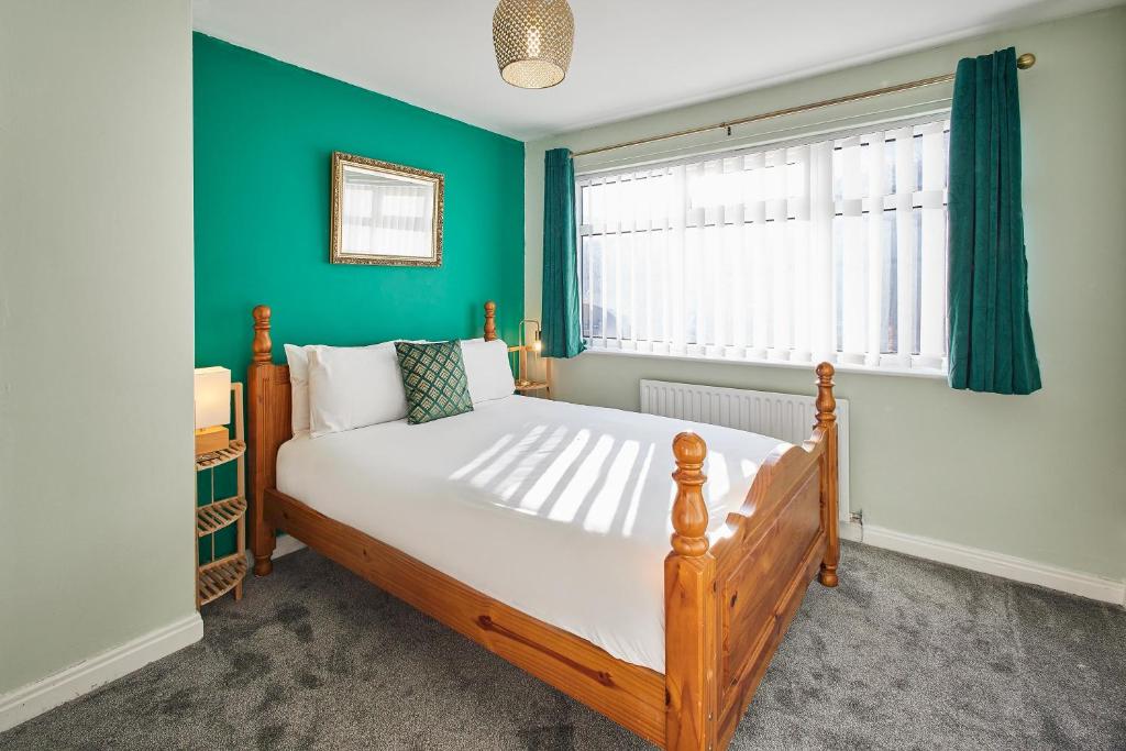 a bedroom with a large bed with a green wall at Host & Stay - St Mark's Close in Marske-by-the-Sea