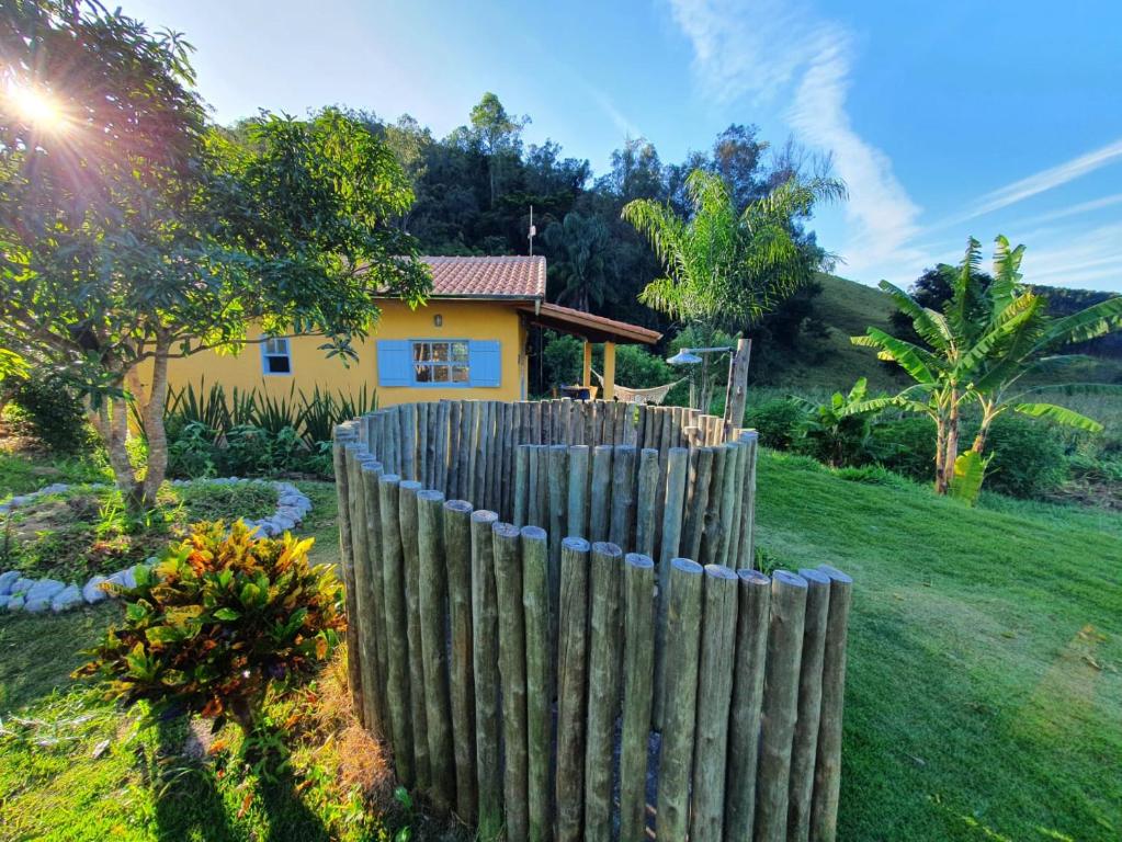 una valla de madera frente a una casa en Sitio Carpir - conforto, charme e natureza a 2h de SP, en Paraibuna