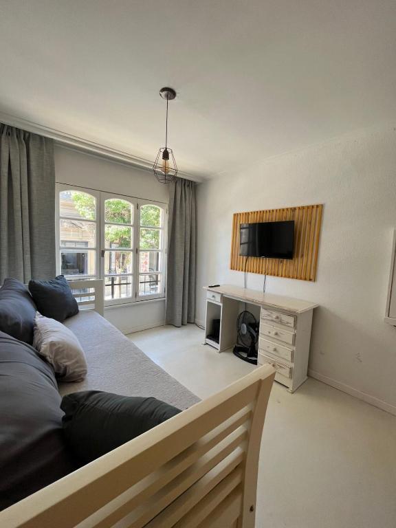 a bedroom with a bed and a tv on the wall at Departamento Monoambiente céntrico en Tandil in Tandil