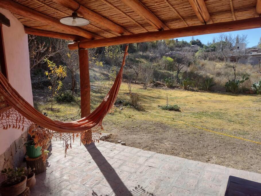 una hamaca en un porche con vistas a un campo en La Escondida, en Tilcara