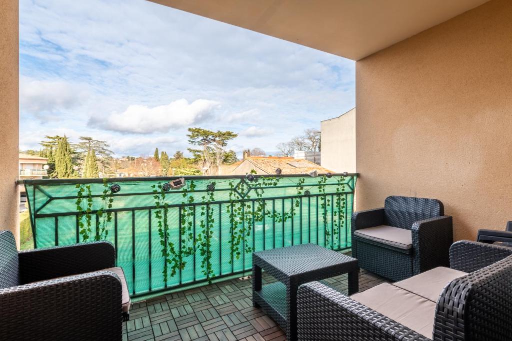 einen Balkon mit Stühlen und einem grünen Geländer in der Unterkunft L'écrin Jardin des Remparts - Parking Privé - Terrasse in Carcassonne