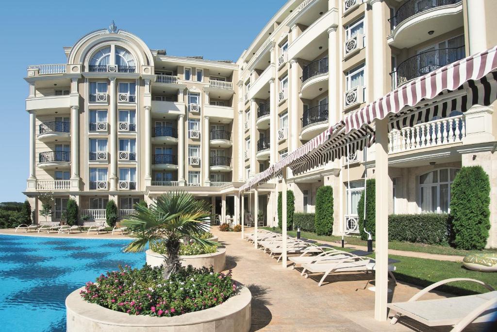 a hotel with a swimming pool in front of a building at Rena Hotel - All Inclusive in Sunny Beach