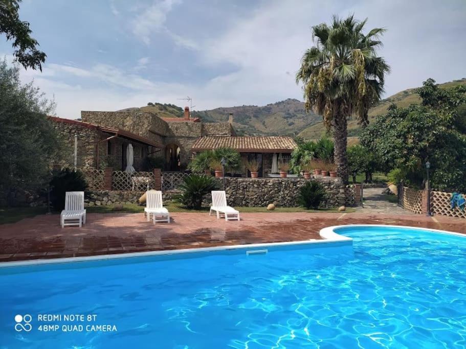 eine Villa mit einem Pool vor einem Haus in der Unterkunft I Casali in Calatabiano