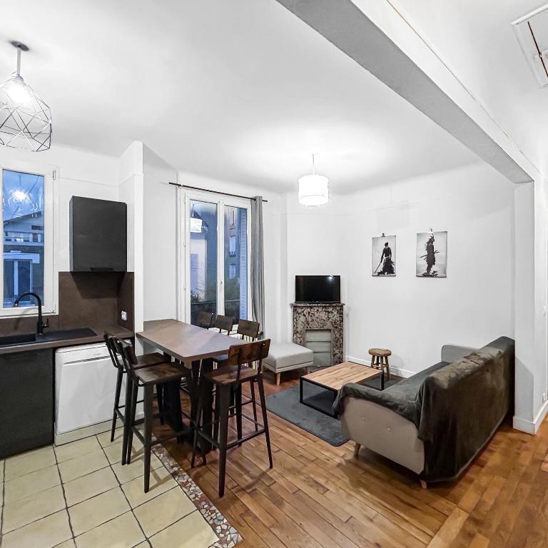 une cuisine et un salon avec une table et un canapé dans l'établissement Un Coin Tranquille de Bagneux, à Bagneux