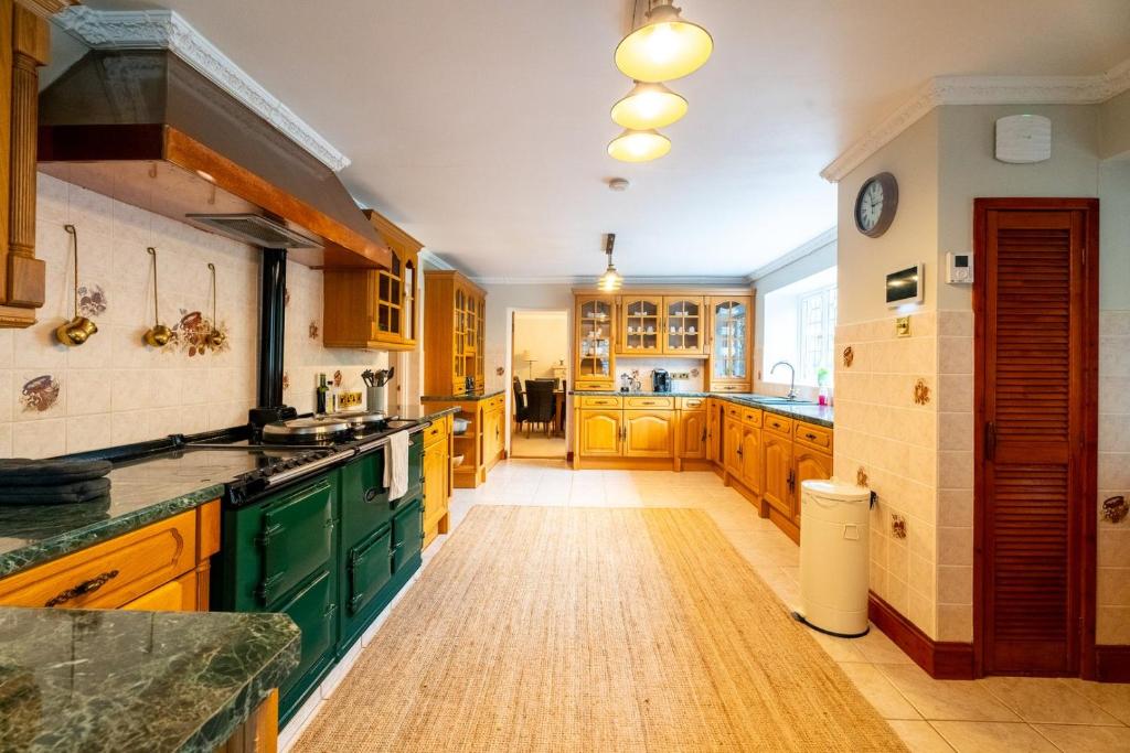 cocina grande con armarios de madera y encimeras verdes en Luxurious Country Retreat in Winford en Bristol