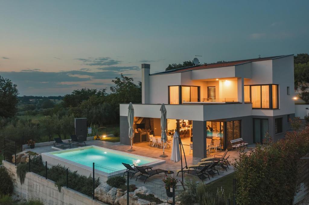 une villa avec une piscine au crépuscule dans l'établissement Villa Boiky - private pool and amazing sea view, Istria, à Materada