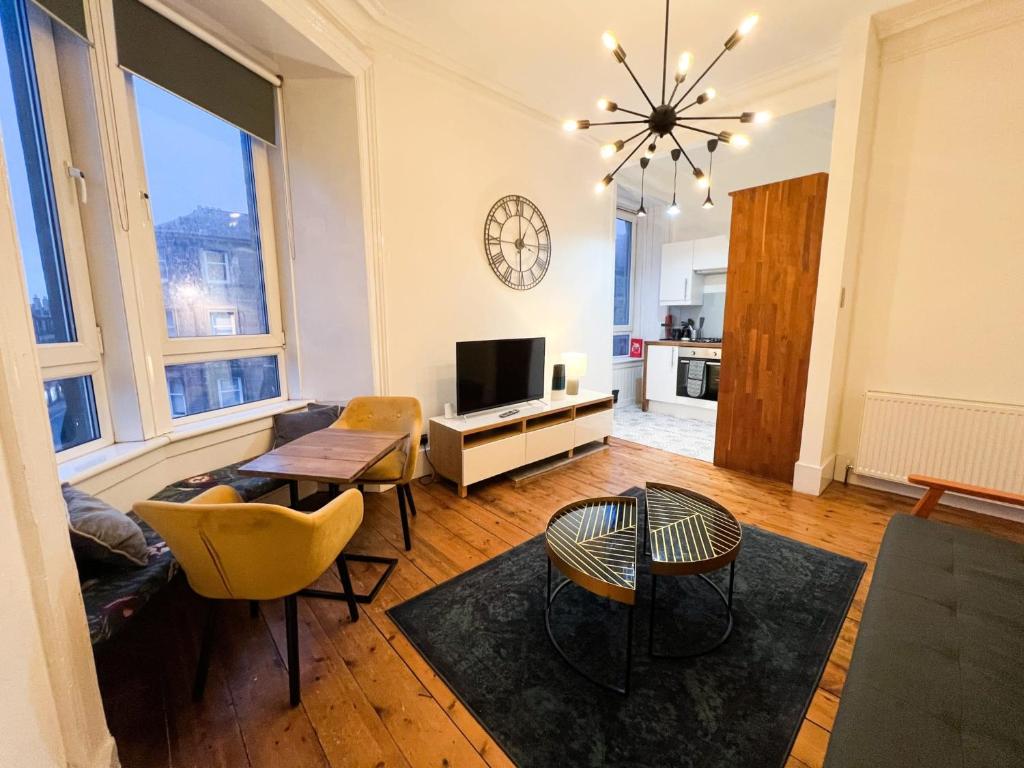 a living room with a television and a table and chairs at Central Edinburgh, Quirky & Modern 1 bed apartment in Edinburgh