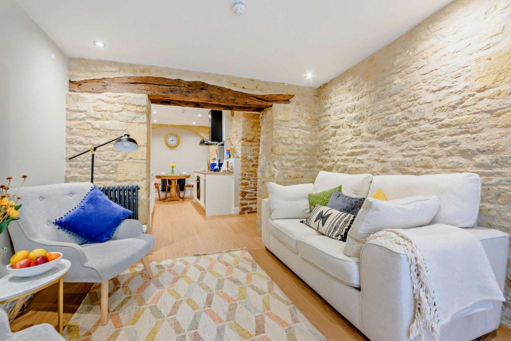 a living room with a white couch and chairs at The Old Workshop in Stow on the Wold