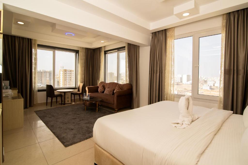 um quarto de hotel com uma cama e uma sala de estar em Diamond Star Hotel فندق النجمة الماسية em Seeb