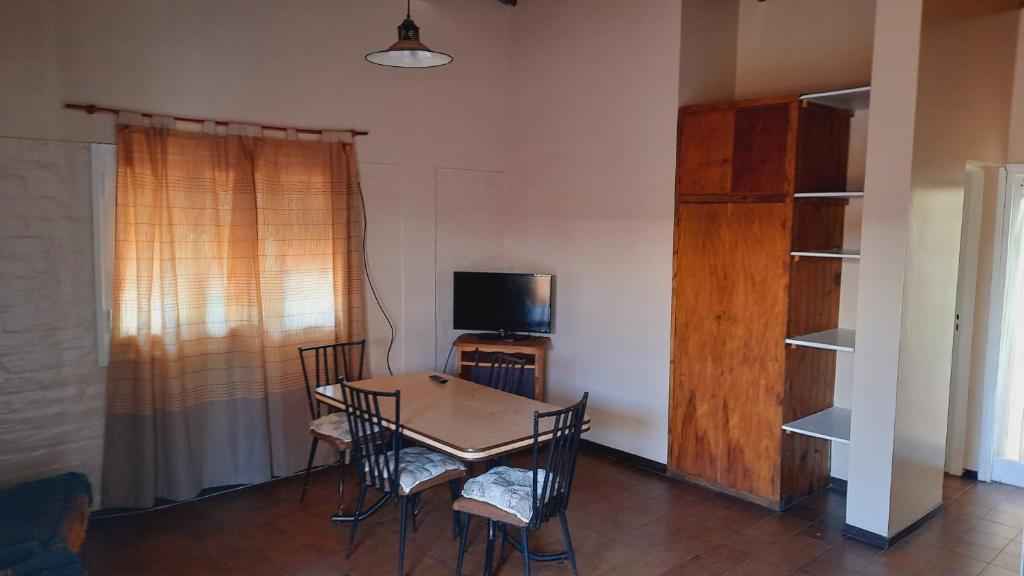 a dining room with a table and chairs and a television at Barbi Room in Guaymallen