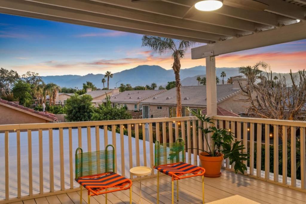 two chairs and a table on a balcony with a view at The Modern Indio Large Family Home With Pool And Spa in Indio