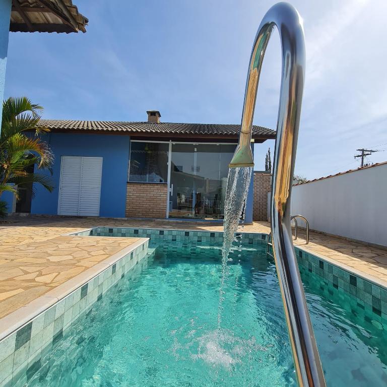 uma piscina com uma fonte de água em Casa em condomínio Ninho Verde 1 em Porangaba